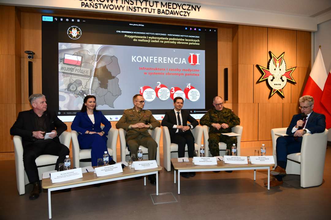 Paneliści siedzący w fotelach podczas debaty.