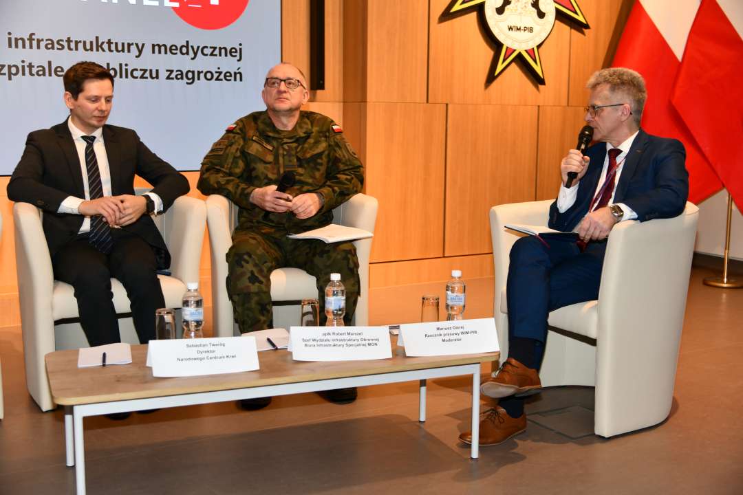 Paneliści siedzący w fotelach podczas debaty.