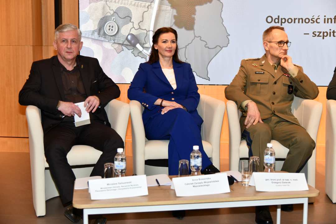 Paneliści siedzący w fotelach podczas debaty.