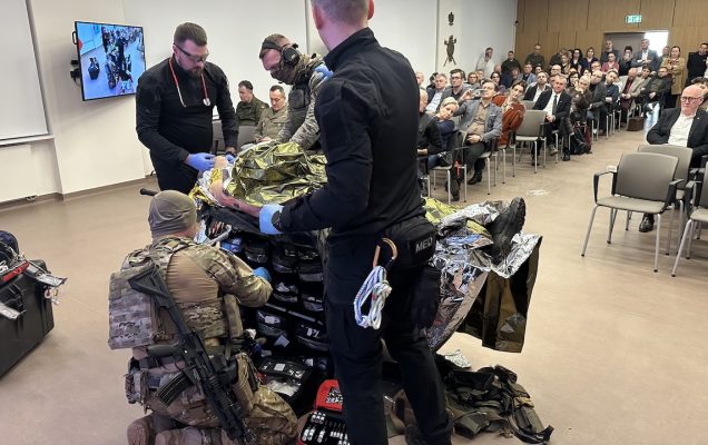 Pokaz ratownictwa medycyny pola walki na auli WIM. Ratownicy przy fantomie poszkodowanego żołnierza.