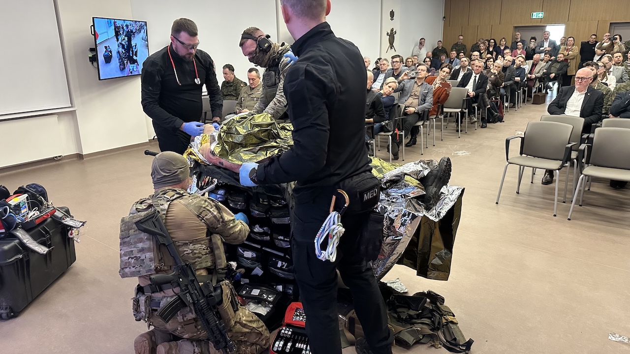 Pokaz ratownictwa medycyny pola walki na auli WIM. Ratownicy przy fantomie poszkodowanego żołnierza.