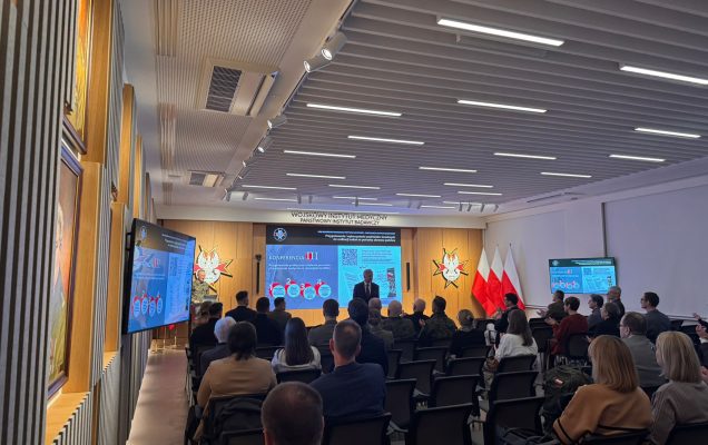 Ujęcie z tyłu sali na słuchaczy konferencji.