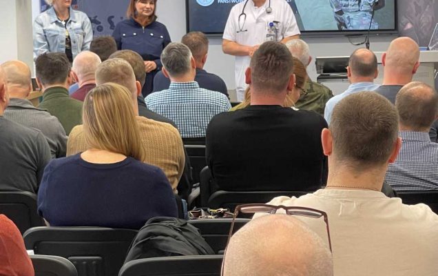 Ujęcie z tyłu sali na słuchaczy i Jarosława Świstaka.