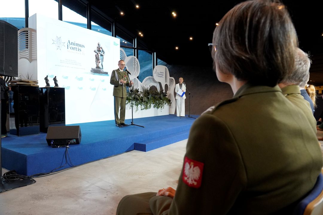 Ujęcie z tyłu sali na widownie i dyrektora WIM na scenie.