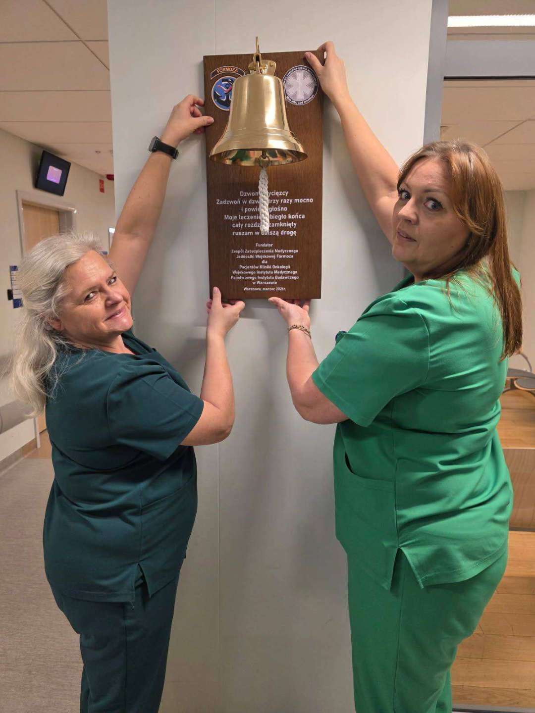 Dwie pielęgniarki prezentują dzwon.