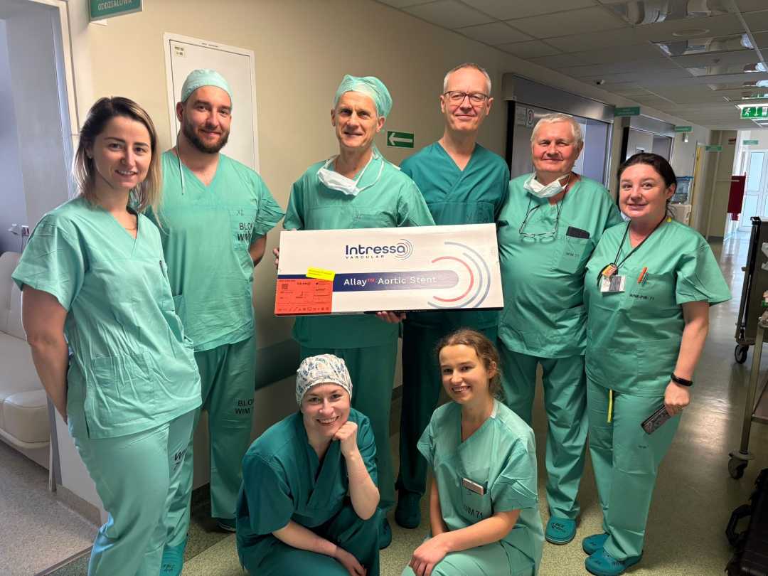 Członkowie zespołu operacyjnego w strojach operacyjnych. Operator po środku trzyma tablicę z certyfikatem Extenso.