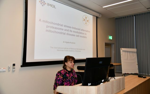 Agata Kodroń przy tablicy z prezentacją prowadzi wykład w sali LOMTI.