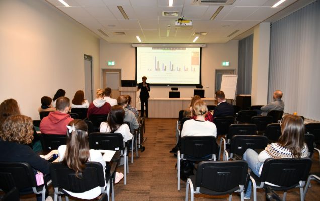 Ujęcie z tyłu sali na słuchaczy wykładu.