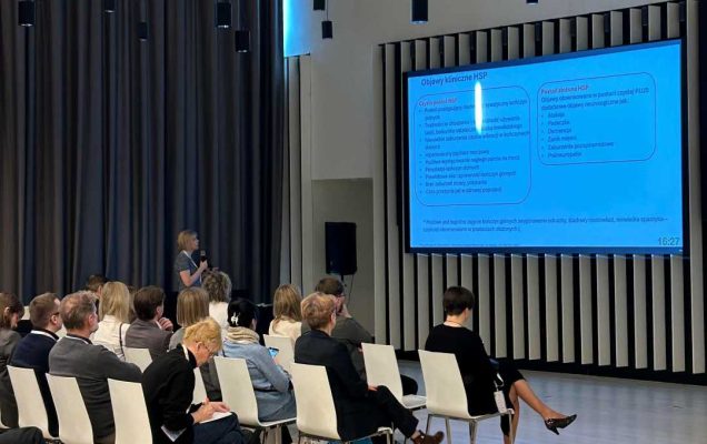 Ujęcie z tyłu sali słuchaczy podczas wykładu na sali konferencyjnej.