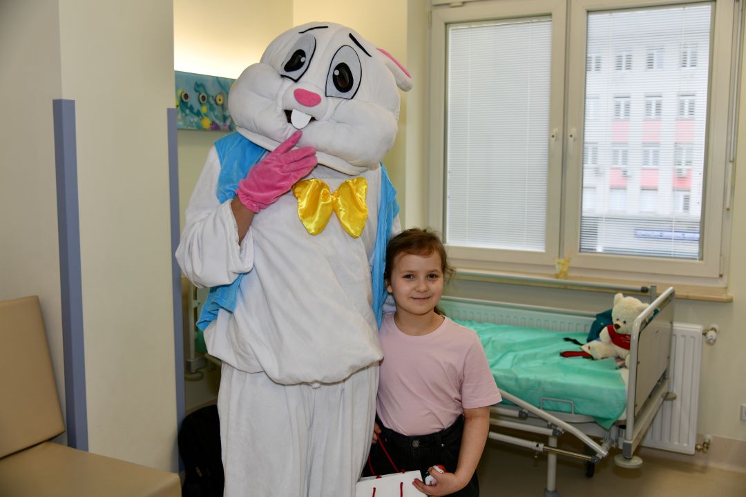 Zajączek wielkanocny z małą pacjentką w sali szpitalnej.