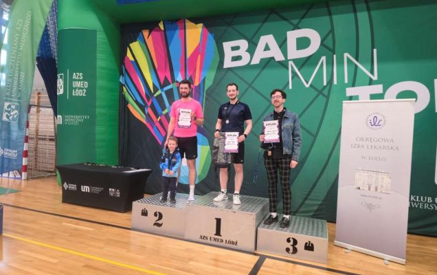 Wojciech Kurzyński na hali sportowej stoi na podium z 1 miejscem.