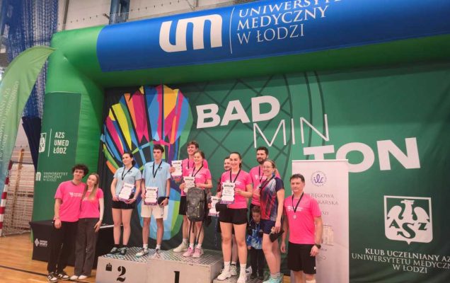 Hala sportowa. Zwyciężczynie na podium z dyplomami w rekach.