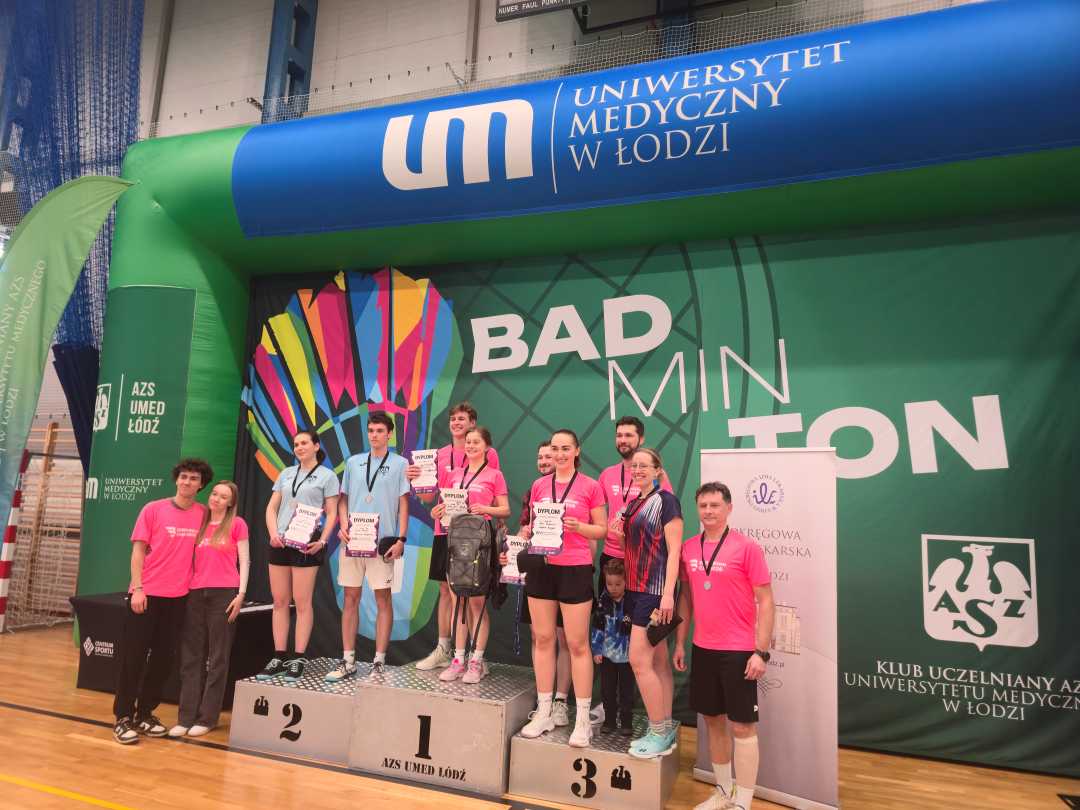 Hala sportowa. Zwyciężczynie na podium z dyplomami w rekach.