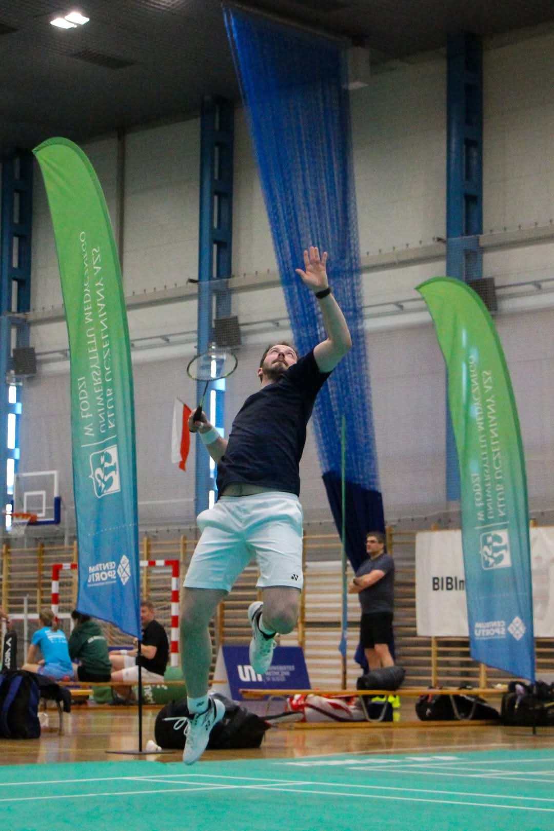 Wojciech Kurzyński uchwycony w podskoku na hali sportowej podczas gry.