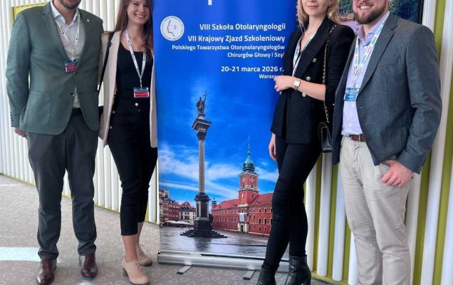 Zdjęcie grupowe prelegentów na tle ścianki z wydarzeniem.