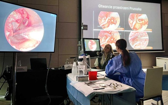 Przyciemniona sala. Przy stole laboratoryjnym siedzą dwie młode kobiety. Przed nimi na dwóch ekranach widok preparatów mikroskopowych.