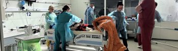 Ćwiczenia na sali medycznej w Centrum Symulacji Medycznej. Medycy nad stołem z fantomem na sali operacyjnej.