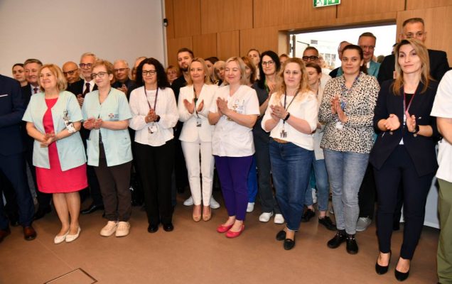 Goście i pracownicy WIM stojący na auli.