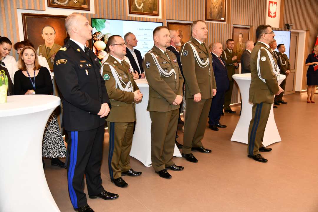 Goście i pracownicy WIM stojący na auli.