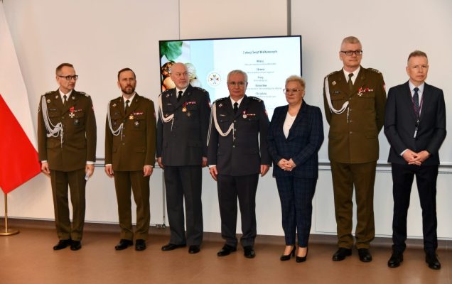 Przedstawiciele dyrekcji WIM stojący na auli podczas uroczystości.