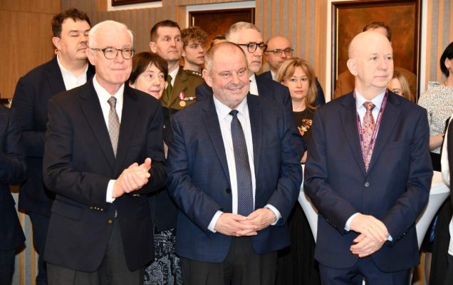 Alojzy Nowak, profesor Kalicki oraz goście i pracownicy WIM stojący na auli.