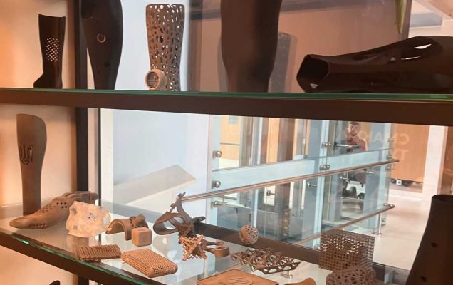 Elementy wydrukowane drukarką 3d protez kończyn i ich elementów w gablocie szklanej.