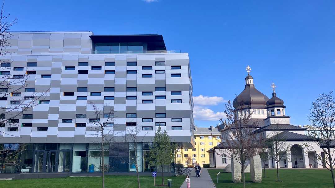 Na pierwszym tle nowoczesny budynek, na drugim planie zabytkowa cerkiew.