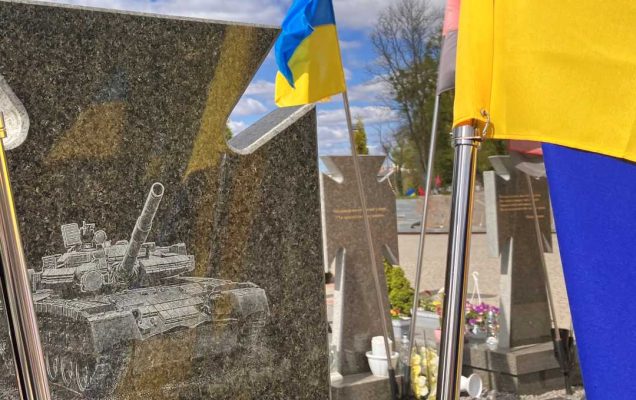 Nagrobek na cmentarzu lwowskim. Na marmurze wygrawerowany czołg obok nagrobka osadzone dwie flagi Ukrainy.