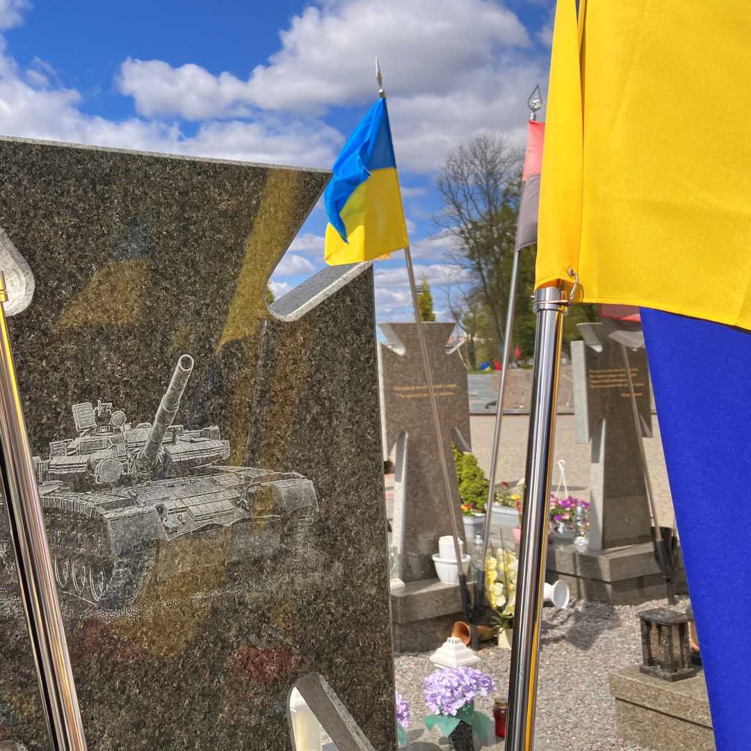Nagrobek na cmentarzu lwowskim. Na marmurze wygrawerowany czołg obok nagrobka osadzone dwie flagi Ukrainy.