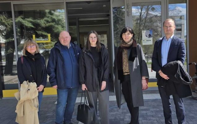 Zdjęcie grupowe naukowców z Kliniki Psychiatrii WIM przed wejściem do budynku konferencyjnego.