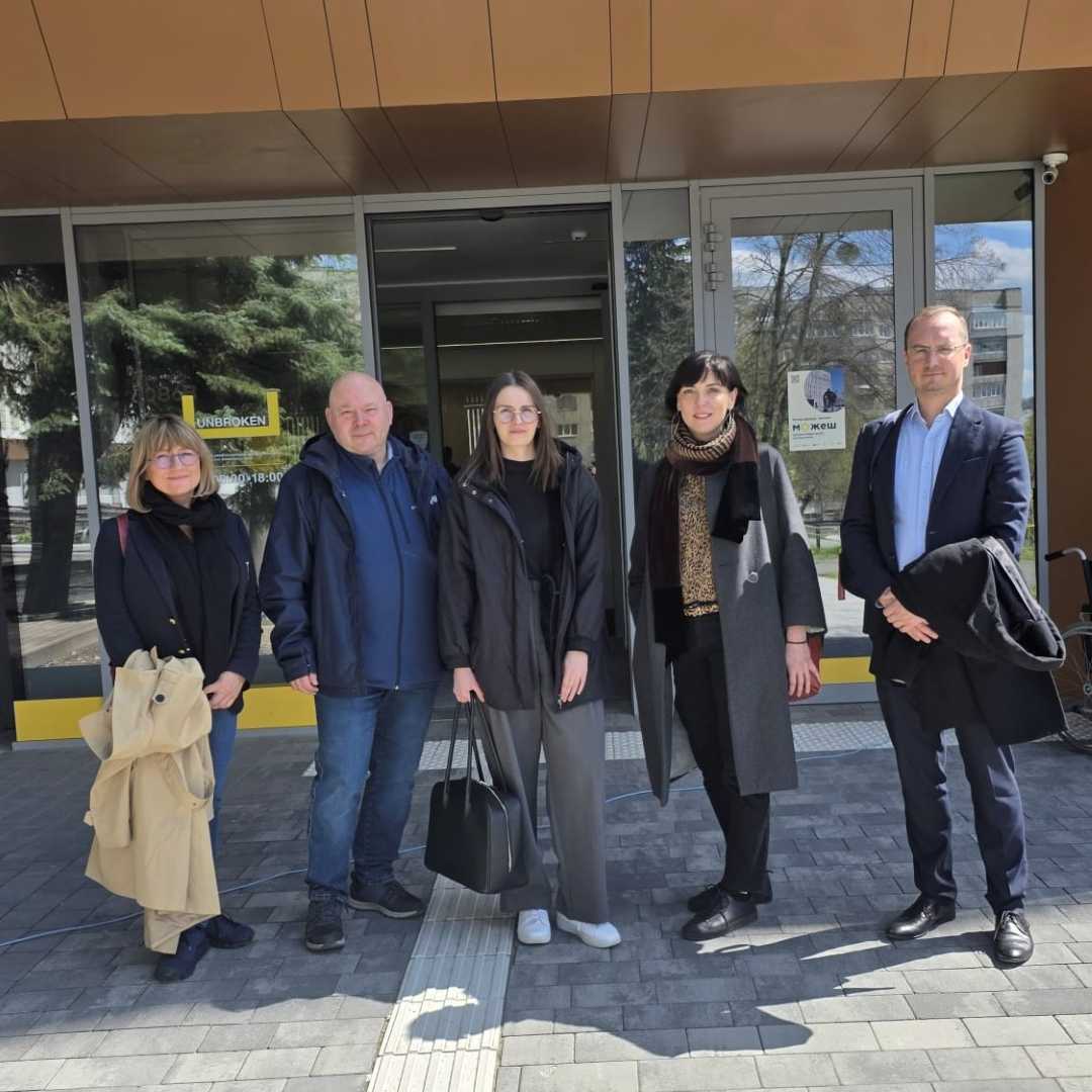Zdjęcie grupowe naukowców z Kliniki Psychiatrii WIM przed wejściem do budynku konferencyjnego.