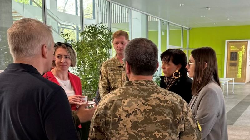 Dyskutujący na korytarzu naukowcy.