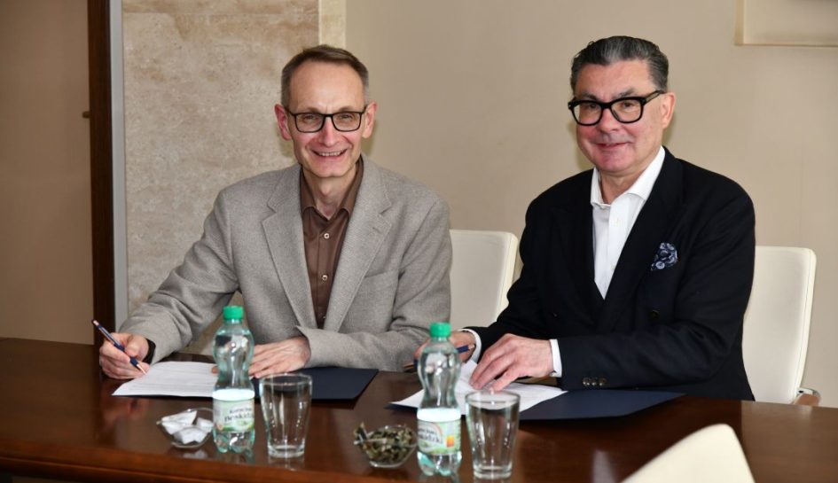 Dyrektor WIM i Cezary Kozanecki pozują do zdjęcia podczas podpisnaia umowy.