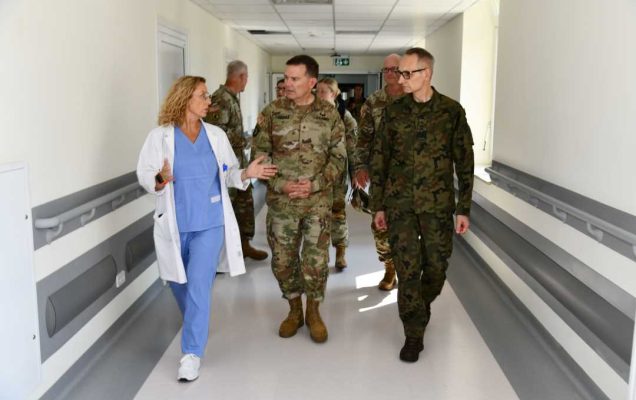 Przedstawiciele US Army razem z Aldoną Chloupek oraz Dyrektorem WIM idą korytarzem i rozmawiają.