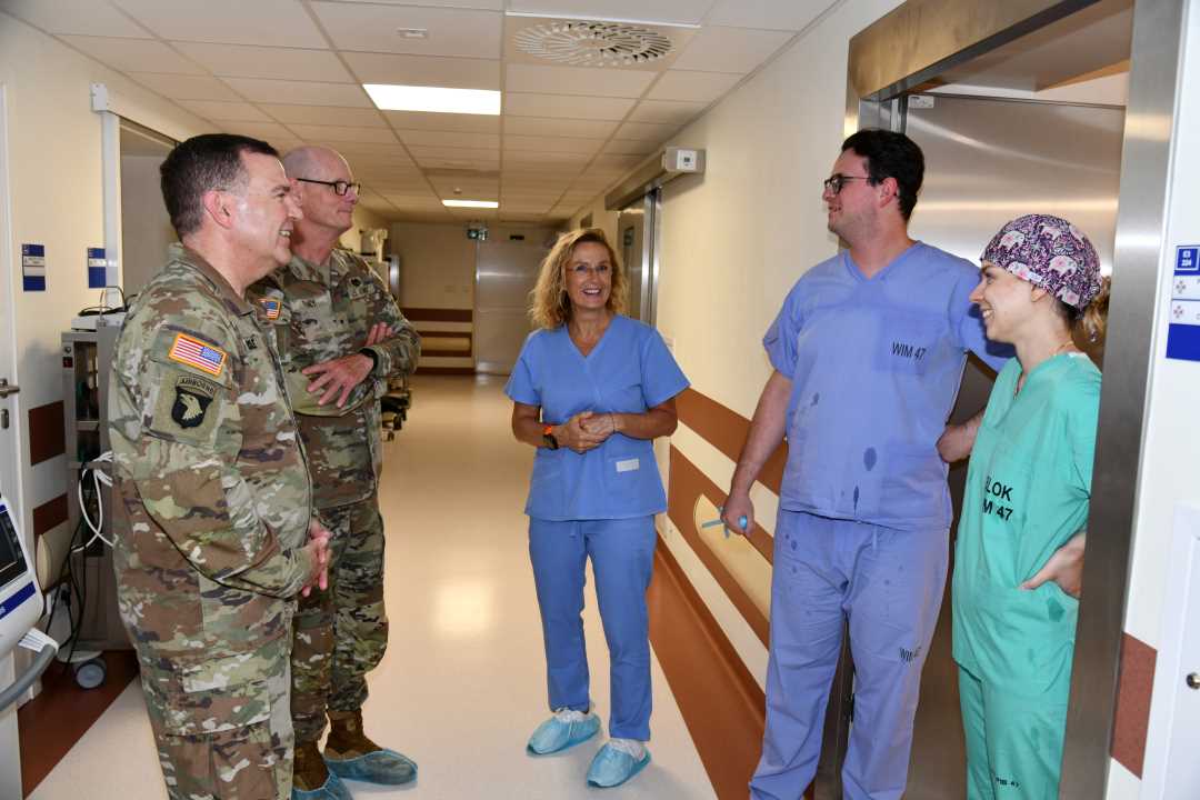 Przedstawiciele US Army oraz pracownicy WIM rozmawiają na korytarzu.