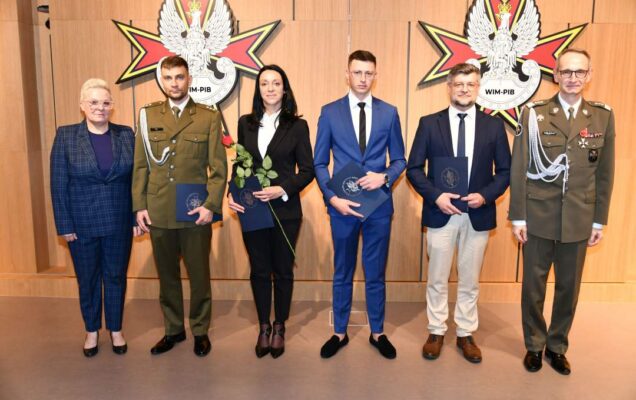 Wyróżnieni pracownicy WIM pozują do zdjęcia z dyrektorem WIM.