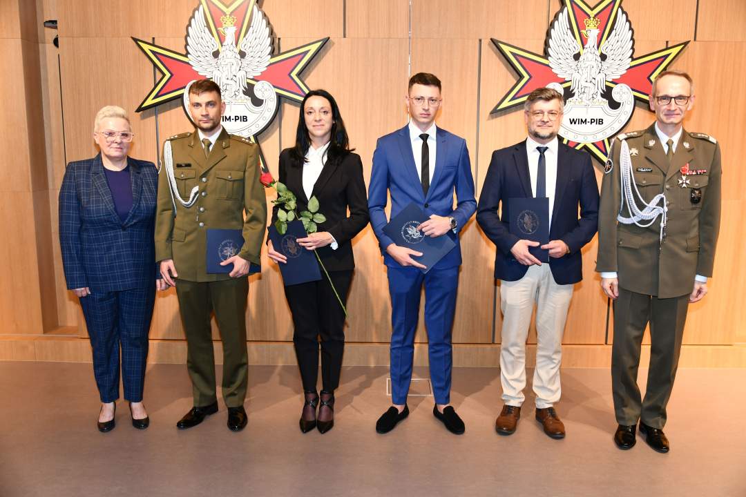 Wyróżnieni pracownicy WIM pozują do zdjęcia z dyrektorem WIM.