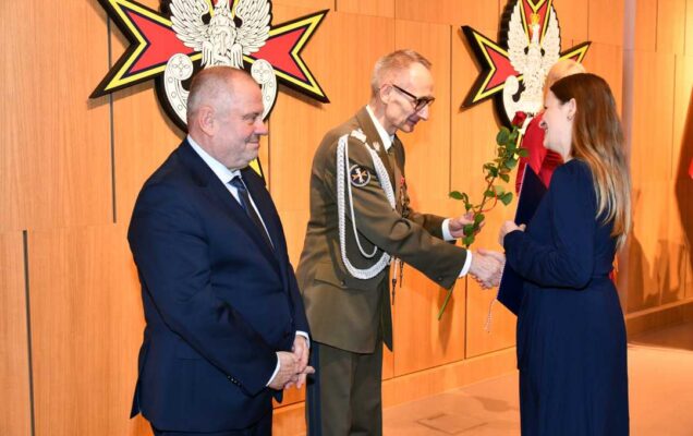 Alojzy Nowak i Grzegorz Gielerak wręczają pracowniczce WIM dyplom.