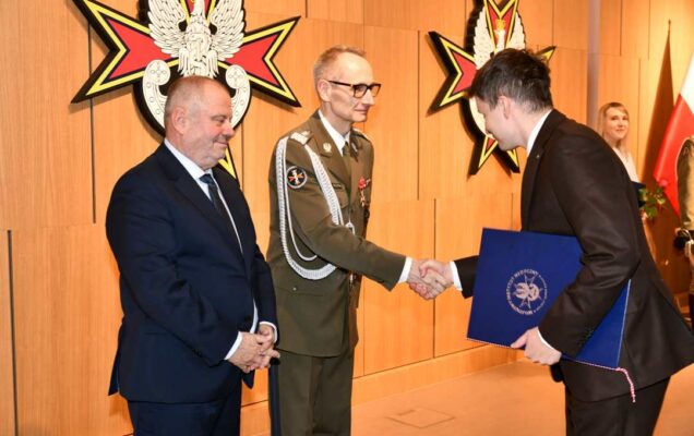Alojzy Nowak i Grzegorz Gielerak wręczają pracownikowi WIM dyplom.