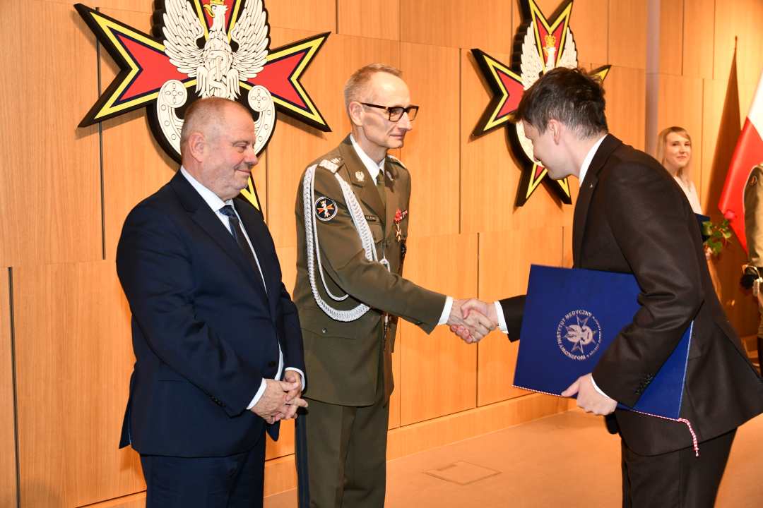Alojzy Nowak i Grzegorz Gielerak wręczają pracownikowi WIM dyplom.