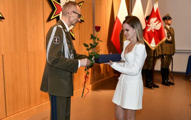 Grzegorz Gielerak wręcza pracowniczce WIM dyplom.