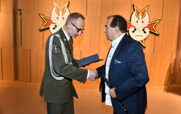 Dyrektor WIM wręcza dyplom laureatowi.