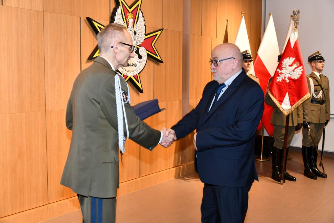 Grzegorz Gielerak wręcza pracownikowi WIM dyplom.