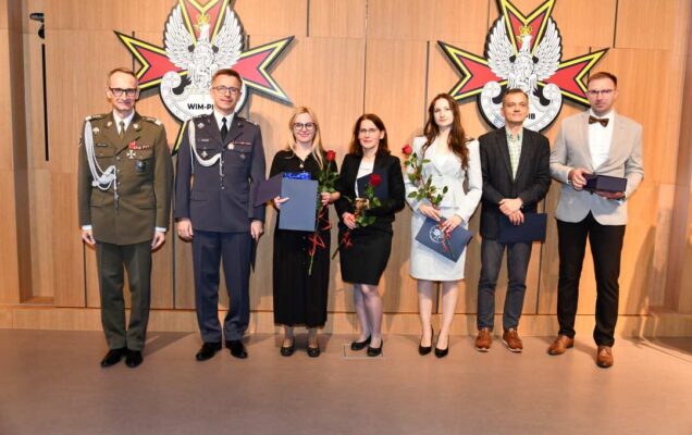 Dyrektor WIM pozuje do zdjęcia z laureatami.