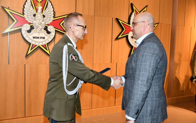 Dyrektor WIM wręcza dyplom laureatowi.