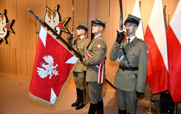 Poczet sztandarowy. Trzech żołnierzy prezentujących szble, jeden z nich trzyma sztandar.