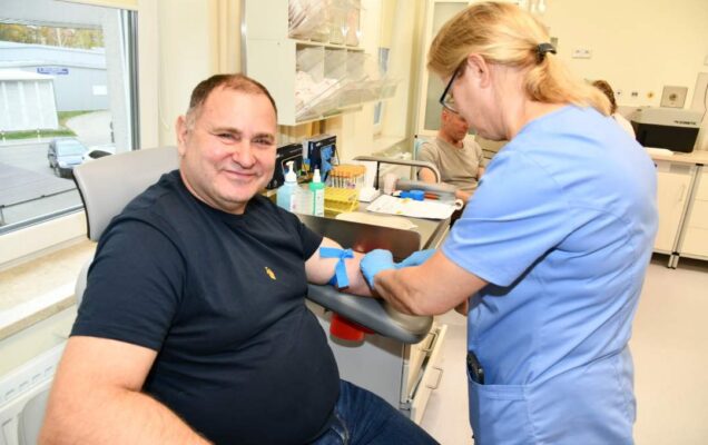 Pielęgniarka pobiera krew weteranowi w gabinecie lekarskim.