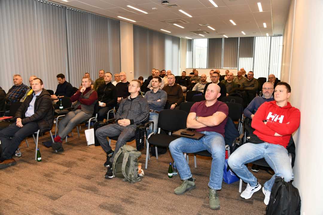 Weterani siedzą na sali wykładowej.