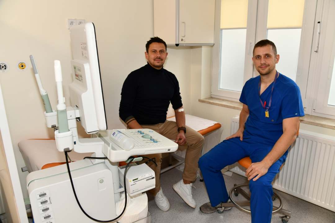 Weteran po badaniu siedzi na kozetce lekarskiej w gabinecie lekarskim, obok niego siedzi lekarz.