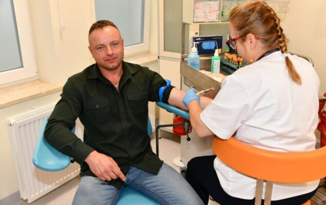 Pielęgniarka pobiera krew weteranowi w gabinecie lekarskim.